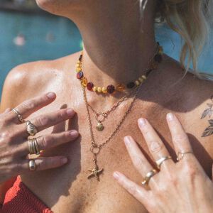 Naszyjnik w świetle słońca ukazujący różnorodne odcienie kolorowych bursztynów.