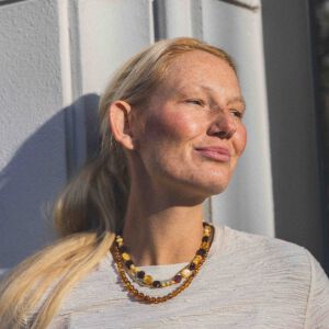 Ujęcie z większej odległości prezentujące naszyjnik z płaskich bursztynów w prostej stylizacji.