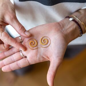 Kolczyki spirale greckie pokazane na dłoni