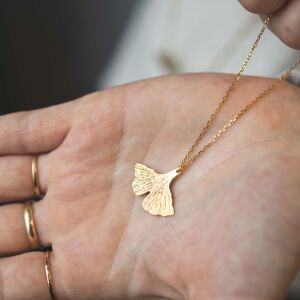 Zbliżenie na złotą zawieszkę liścia miłorzębu symboliczną biżuterię z kolekcji handmade Matyldy Zielińskiej
