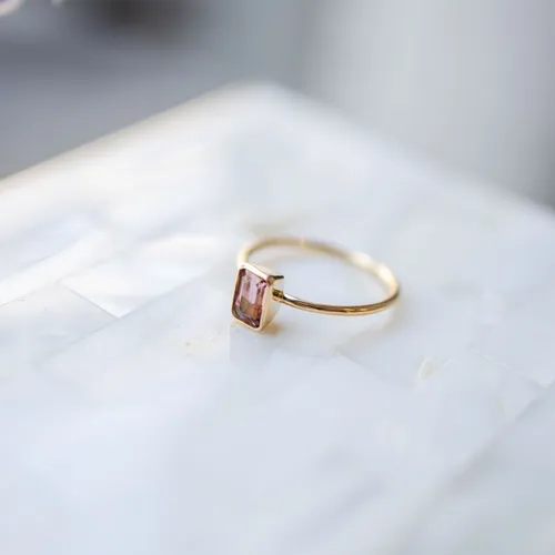 Złoty pierścionek z prostokątnym różowym turmalinem w stożkowej oprawie