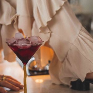 Delikatny pierścionek z sercem ułożony na kieliszku, wykonany ze srebra próby 925 i pokryty złotem