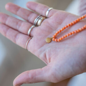 Artystyczna biżuteria koralowa w nowoczesnej odsłonie pomarańczowy naszyjnik z naturalnego korala stworzony przez Matyldę Zielińską z myślą o podróżach i słońcu Sycylii