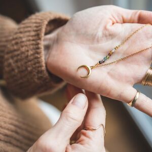 Zawieszka lunula w formie srebrnego półksiężyca zdobiona kamieniami minimalistyczna biżuteria handmade z polskiej pracowni
