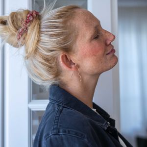 Nieregularne kolczyki serca zaprezentowane na uchu w świetle dziennym pokazującym ich naturalną fakturę