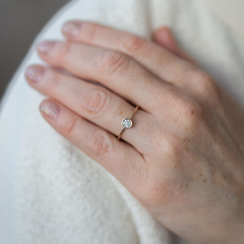 Złoty pierścionek z białym diamentem w stożkowej oprawie