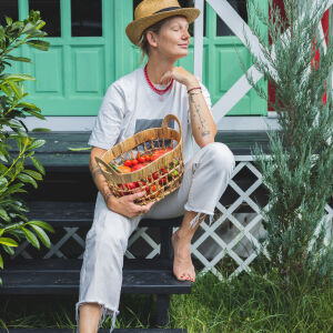 Matylda Zielińska w oddali prezentuje kompozycję naszyjników na szyi, z naszyjnikiem z naturalnego czerwonego korala jako głównym elementem stylizacji.