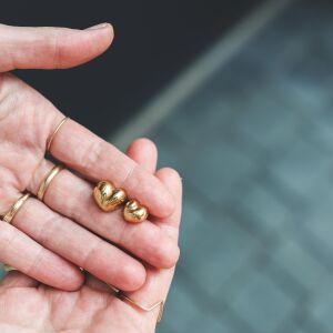Kolczyki asymetryczne z matowym wykończeniem w kolorze złotym zaprezentowane w detalicznym ujęciu