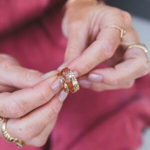 Frezowane obrączki ukazane w zbliżeniu z wyraźnym wzorem cięć na powierzchni jako przykład ręcznie robionej biżuterii.